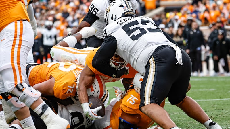 Tennessee running back Desean Bishop, with the ball, dives over the goal for a touchdown...