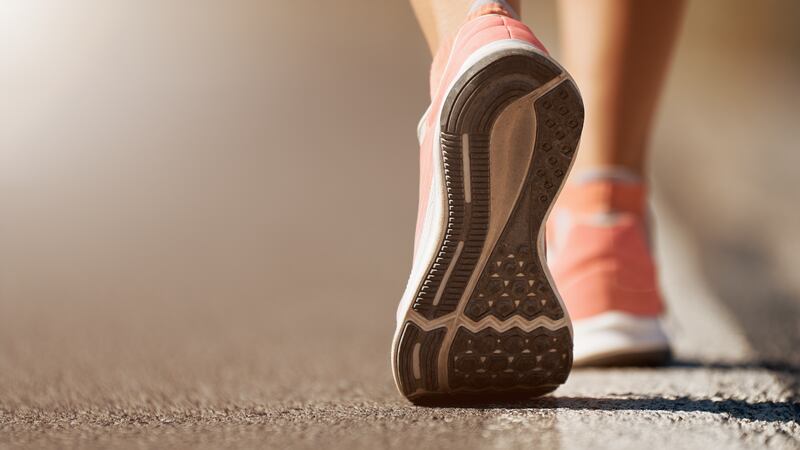 Running shoe closeup of woman running on road with sports shoes