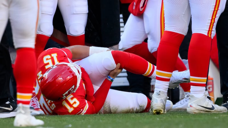 Kansas City Chiefs quarterback Patrick Mahomes grabs his knee after being injured during the...