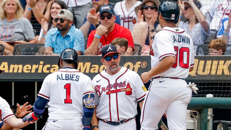 Atlanta Braves manager Walt Weiss, center, greets Ozzie Albies (1) and Drake Baldwin, right...