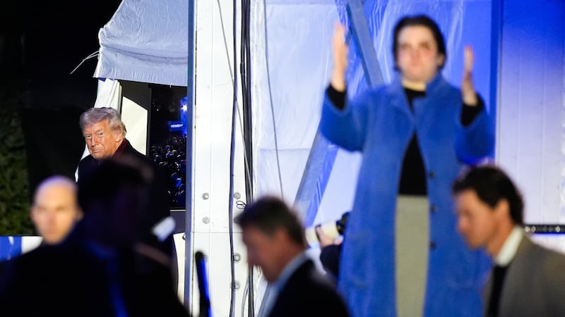 An American Sign Language interpreter, right, signs as President Donald Trump arrives for the...