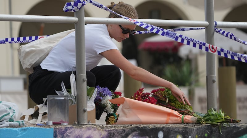Shenna McClean lays flowers at a memorial at Sydney's Bondi Beach, Monday, Dec. 15, 2025, a...
